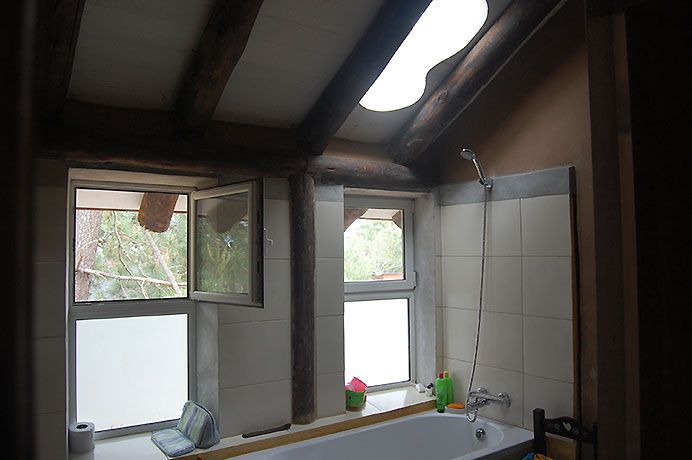 En baños se combina revoque de arcilla muy fina con terminaciones de estucados y cerámica; iluminación natural zenital.