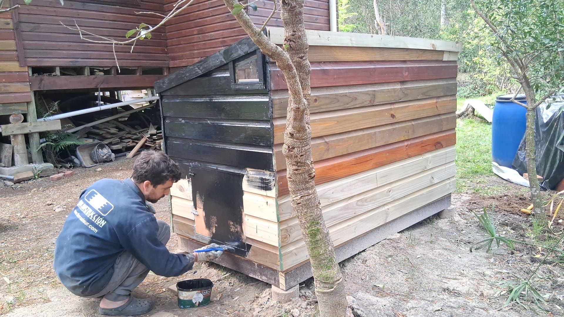 Caseta del sanitario seco en construcción, con el triángulo superior de ventilación y el frente en proceso de pintado.